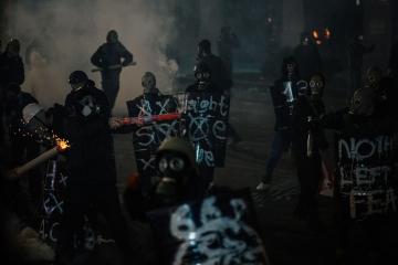 Young people protect themselves from tear gas capsules with handmade shields.