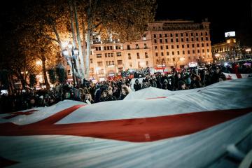 Protesters hold up a huge Georgian flag on Freedom Square. Since the protest started, people began o ...