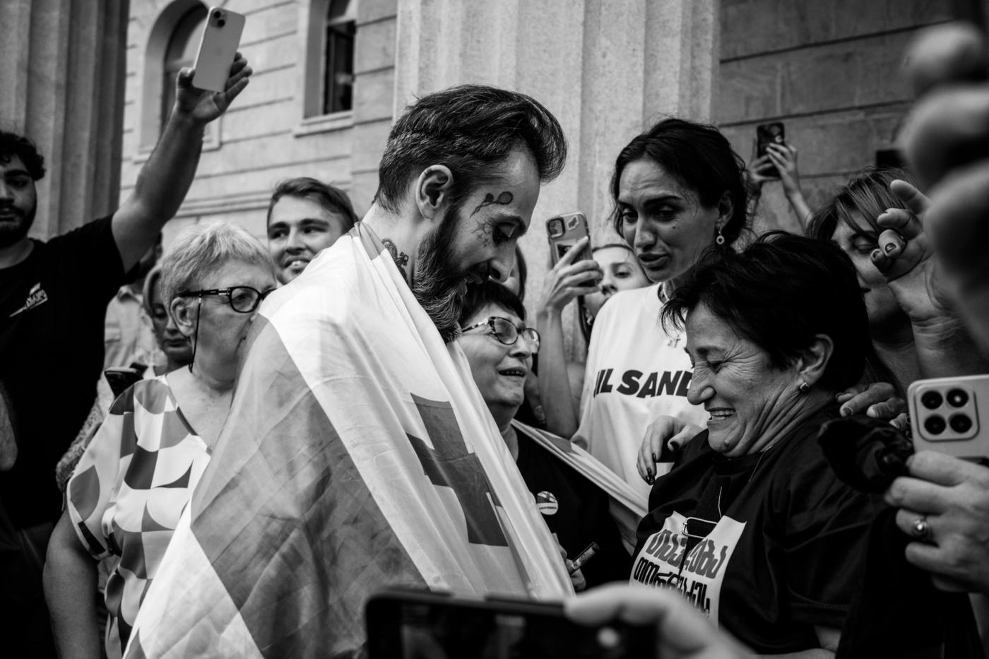 მარიზი საქართველოს დროშას ახვევს სასამართლოს დარბაზიდან გათავისუფლებულ ნიკა კაციას. 3 სექტემბერი, 20 ...