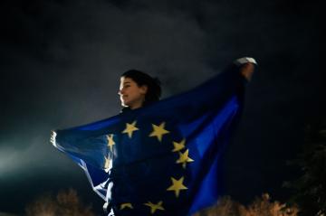 აქციის მონაწილე ევროკავშირის დროშით. მასშტაბური დემონტრაციები ევროკავშირთან მოლაპარაკების გახსნის გა ...