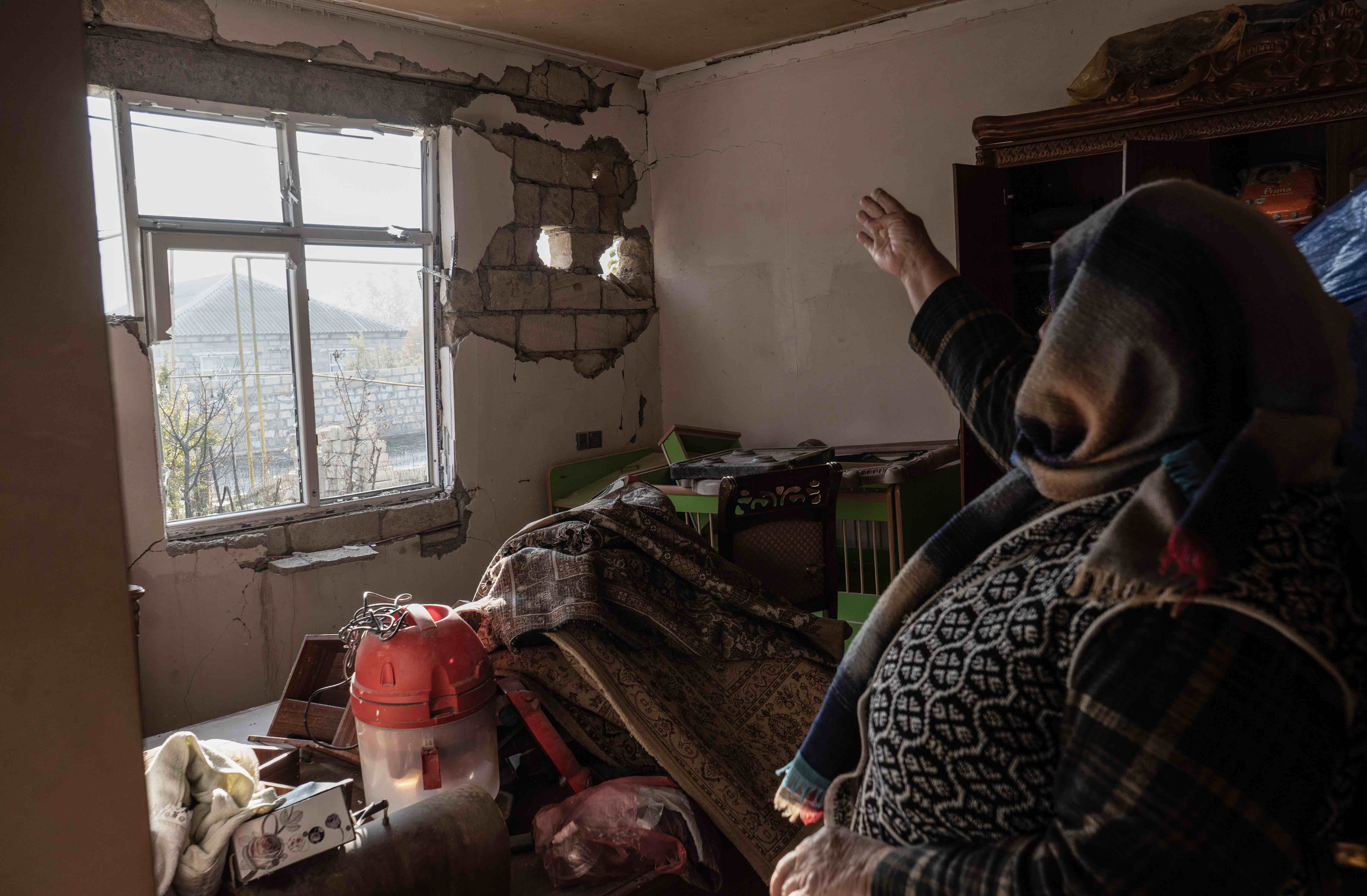 Shahla Gasimova, 60, points out some of the damage her house suffered during the war. She and her hu ...